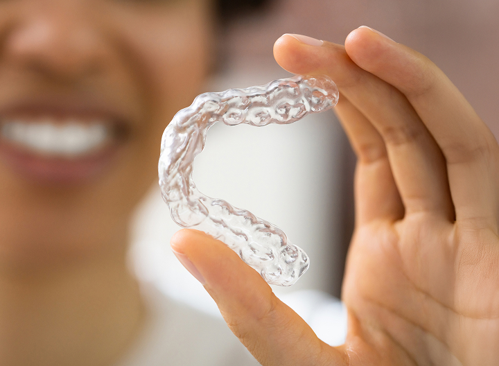 Close Up Of Woman Holding Invisalign Aligner