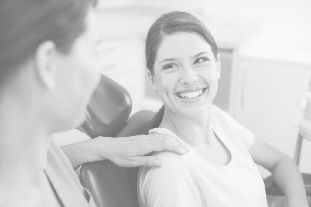 A Dental Patient Being Reasured By A Nurse While Smiling